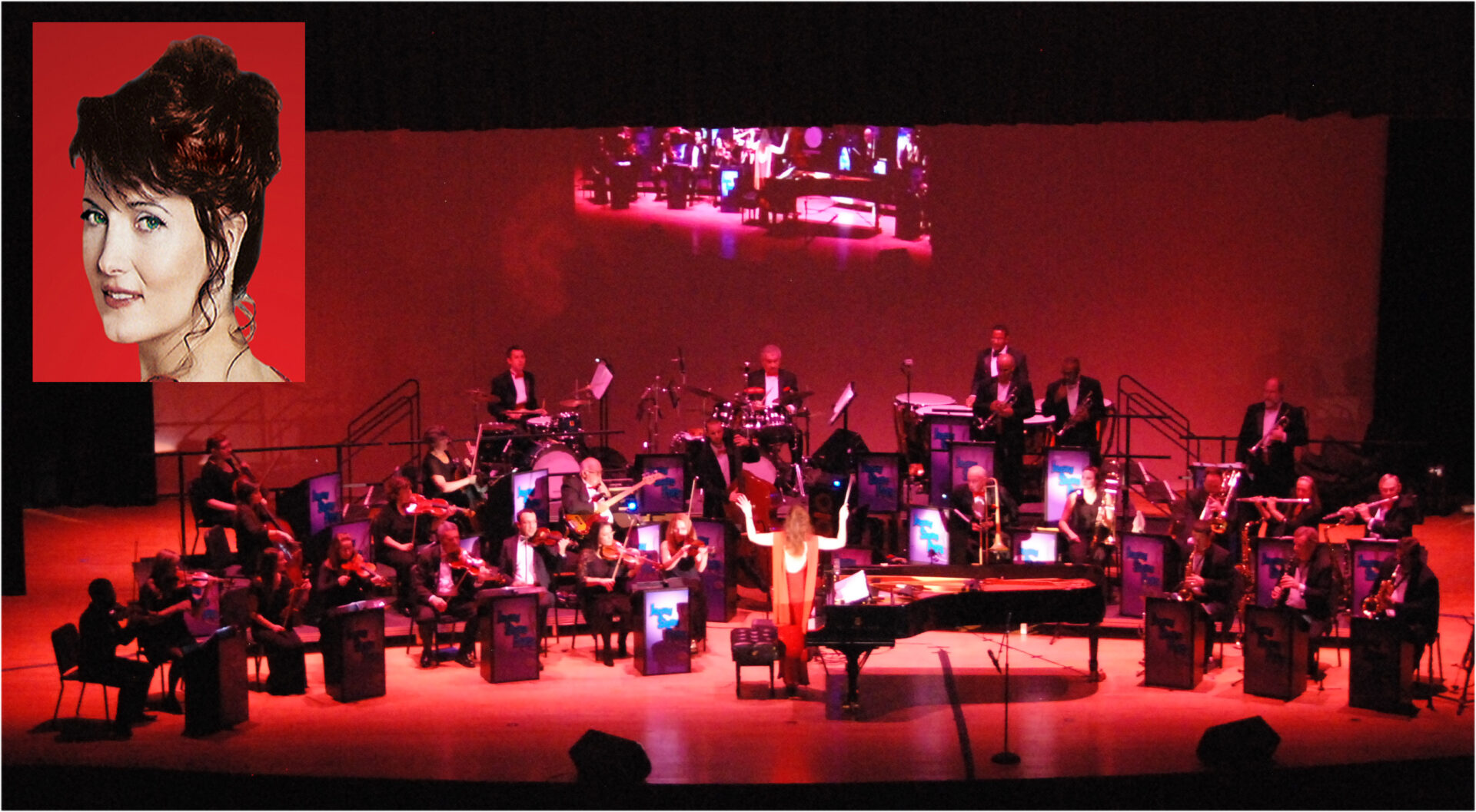 An orchestra with a woman on stage.